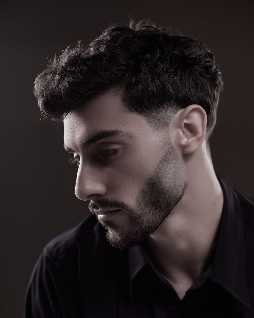 Modèle masculin avec un dégradé américain propre et une barbe parfaitement taillée, formation barbier Cyléa Formations.